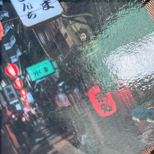 Glossy laminate on a printed street scene, showing a shiny reflective surface.