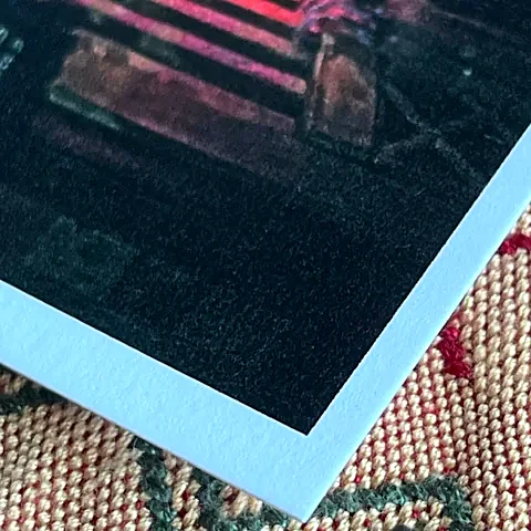 Corner of a photo printed on Art Silk paper, showing its texture and white edge.
