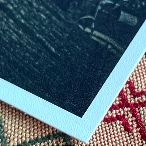 Corner of a photo printed on Eggshell paper, showing its texture and white edge.