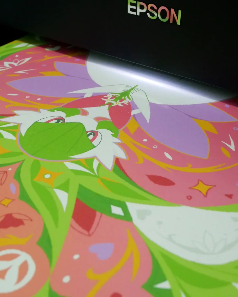 Colorful pink and green illustrated art print coming out of a printer